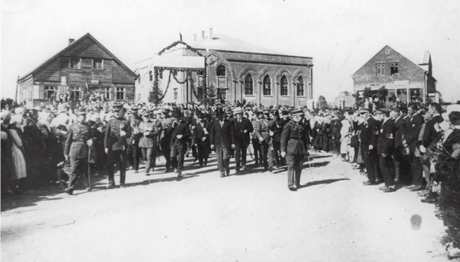 Lietuvos Respublikos Prezidentas A. Smetona su palyda vknos miestelio aiktje Sauls gimnazijos atidarymo ikilmi dien (1928 m. liepos 25 d. ). Tolumoje matosi sinagoga